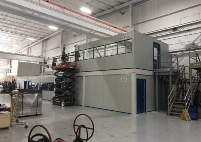 Two-tier modular office during installation while installers work on building the second level