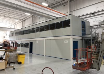 Side profile of two-tier modular office during installation with landing that is connected