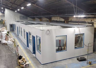 Modular Office Structure with large windows, blue trim during installation.